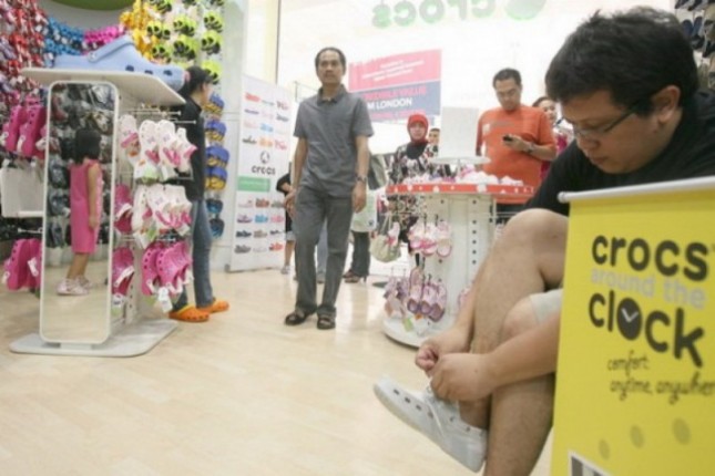 Seorang pengunjung mencoba sebuah produk baru sepatu Crocs saat acara Crocs Around The Clock di Karawaci Mall, Tangerang, Banten. (Foto: Antara)