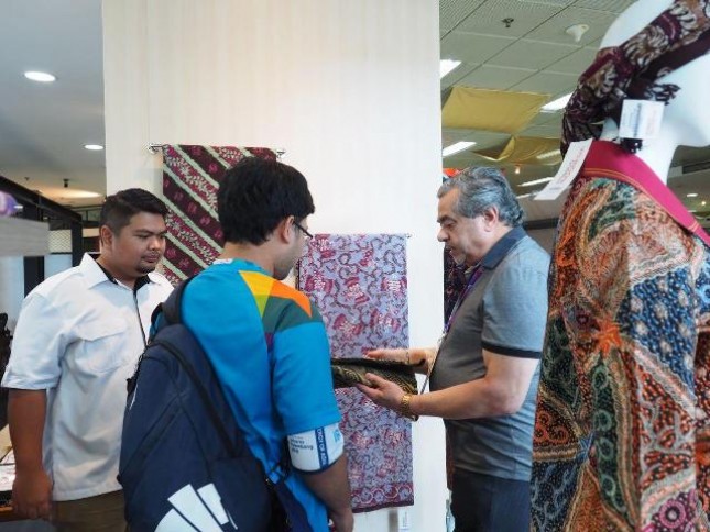 Perwakilan negara peserta Asian Games 2018, secara bergantian mengunjungi gedung Smesco Indonesia. Kedatangan mereka, disambut ramah oleh sejumlah petugas yang menunggu di gerbang utama galeri.