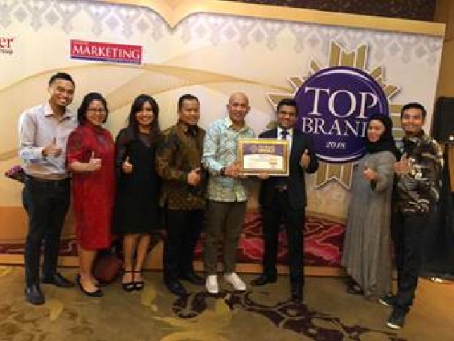 Head of Product Marketing untuk operasi/bisnis Signify di Indonesia, Nikhil Gupta memamerkan penghargaan Top Brand bersama dengan tim lainnya seusai acara penganugerahan (Foto: Dok. Signify) 