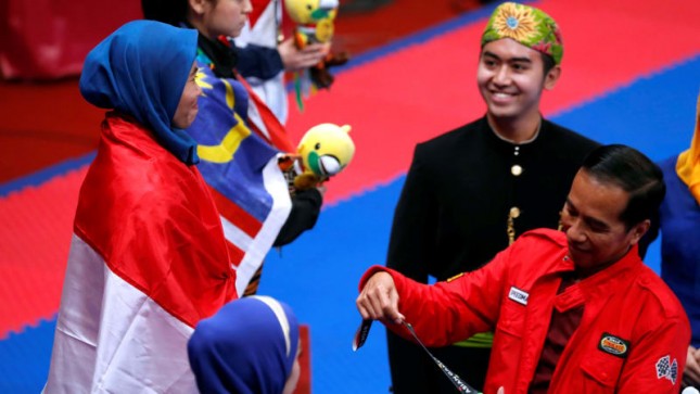 Presiden Jokowi saat menyerahkan medali emas kepada Defia Rosmaniar, atlet taekwondo peraih emas pertama Indonesia di Asian Games 2018, beberapa waktu lalu. (Foto: IST)