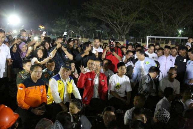 Presiden Jokowi dan Gubernur NTB TGB Zainul Majdi bersama warga korban gempa nonton bareng upacara penutupan Asian Games 2018 di Lapangan Kecamatan Gunungsari, Lombok Barat, NTB, Minggu (2/9/2018)