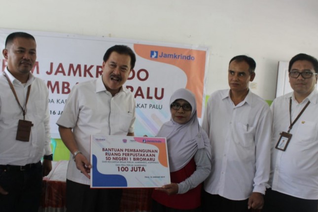 Direktur Utama Perum Jamkrindo Randi Anto (kedua kiri) menyerahkan secara simbolis bantuan pembangunan ruang perpustakaan dan pembuatan taman bacaan untuk SD Negeri 1 Biromaru, dan memberikan pembangunan ruang kelas kepada Madrasah Ibtidaiyah Al Kha
