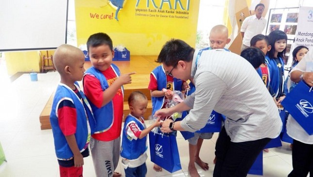Direktur Keuangan WOM Finance, Zacharia Susantadiredja, sedang membagikan bingkisan kepada anak-anak pengidap kanker di Rumah Singgah YKAKI, Jakarta, dalam kegiatan CSR menyambut HUT ke-37 perseroan, Jumat (08/03/2019).
