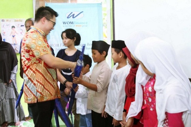 Direktur Keuangan WOM Finance, Zacharia Susantadiredja, sedang membagikan bingkisan berupa alat-alat belajar kepada anak jalanan yang mengikuti edukasi pendidikan seks di Bintaro, Jakarta Selatan, Selasa (30/04/2019).