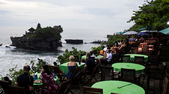 Ilustrasi Turis Berkunjung ke Tanah Lot, Bali (NurPhoto/Getty Images)