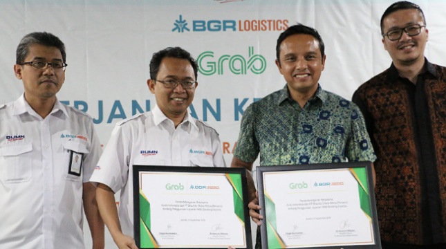 Direktur Utama BGR Logistics, M Kuncoro Wibowo dan Executive Director Grab Indonesia, Ongki Kurniawan, menunjukkan naskah kerja sama