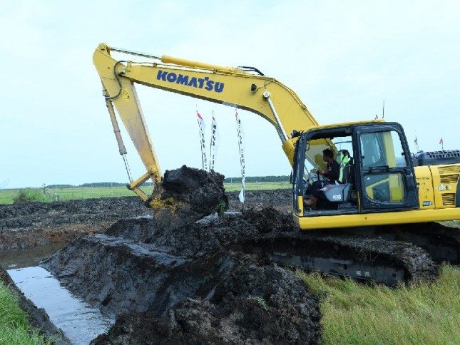 Alat mesin pertanian sedang menggarap lahan