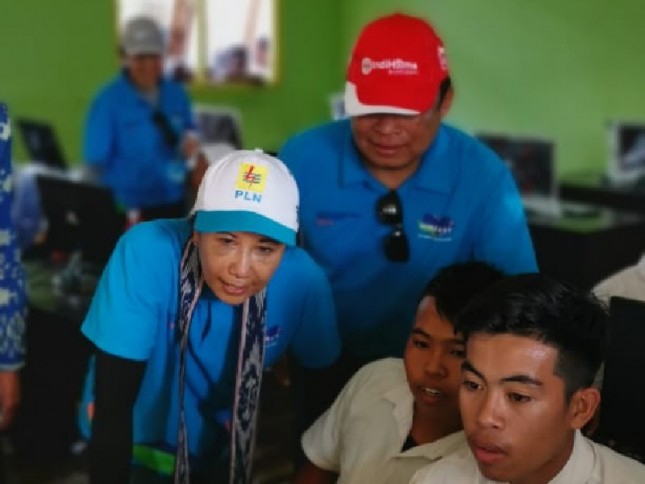 Menteri BUMN RI Rini M Soemarno (kiri) didampingi Direktur Utama Telkom Ririek Adriansyah (kedua dari kiri) tengah berinteraksi dengan siswa SMP Satu Atap Pulau Messah, Kec. Komodo, Kab. Manggarai Barat, NTT.
