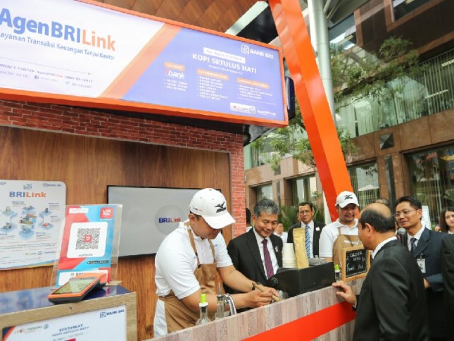 Direktur Utama Bank BRI Sunarso menyaksikan agen BRILink di sebuah cafe