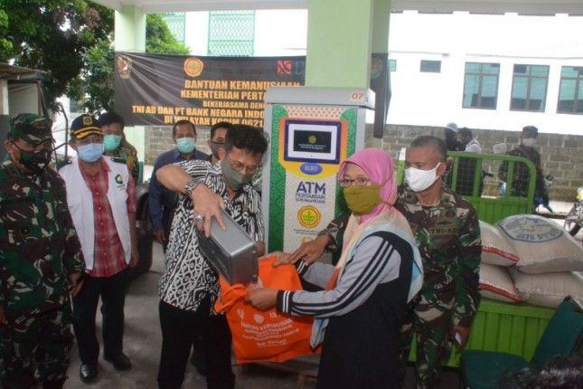 Menteri Pertanian Syahrul Yasin Limpo saat menuangkan beras dari mesin ATM Pangan