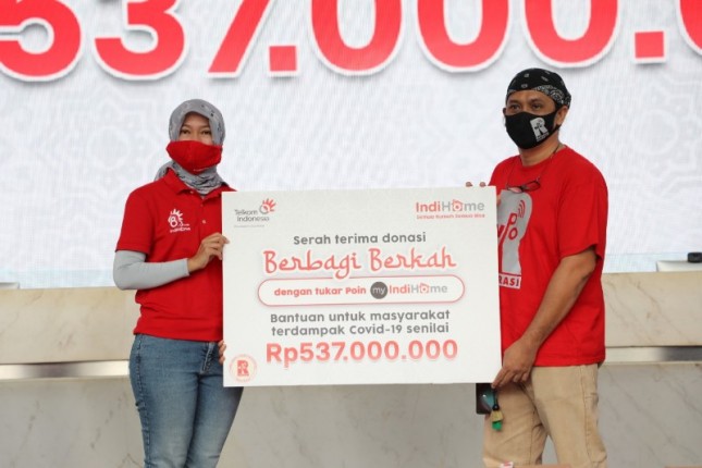 Direktur Consumer Service Telkom Siti Choiriana (kiri) menyerahkan simbolis donasi paket sembako IndiHome Berbagi Berkah kepada Pembina Federasi Rembuk Nasional Pengemudi Online (RNPO) Jaha Nababan 