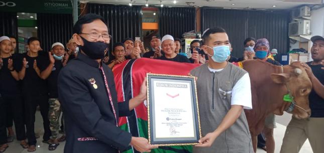 Yusuf Ngadri, senior manager Museum Rekor Indonesia (MURI) memberikan plakat penghargaan rekor MURI kepada youtuber sekaligus pengusaha Putra Siregar.