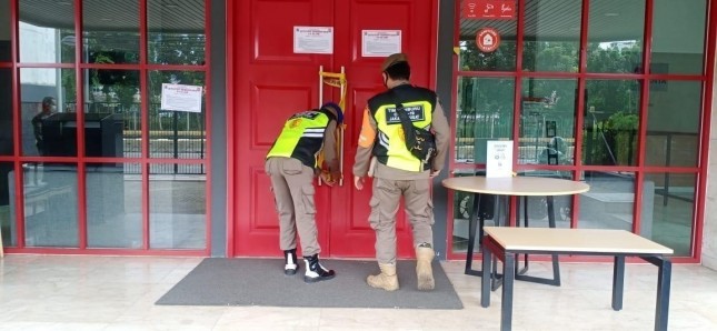 Petugas Membuka Segel OYO Townhouse 2 yang Telah Selesai Disterilisasi dan Siap dibukaKembali untuk Umum 