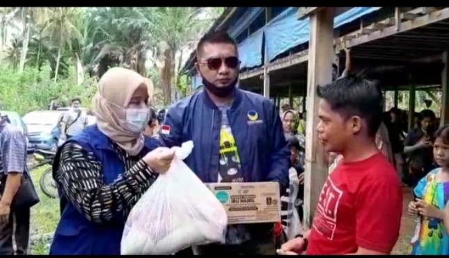 Anggota DPR-RI NasDem dapil Sulbar, Ratih Megasari Singkarru, Ketua Garda NasDem Sulteng, Farid Podungge menyerahkan bantuan ke korban gempa Sulbar