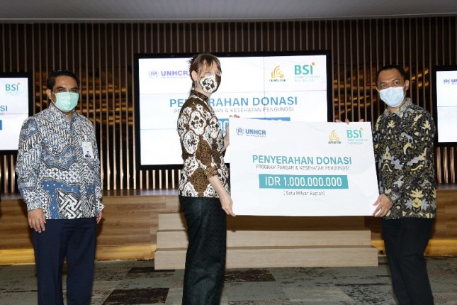 Direktur Sales and Distribution Bank Syariah Indonesia Anton Sukarna menyaksikan penyerahan donasi program pangan dan kesehatan pengungsi di Indonesia dari Ketua Umum Yayasan Amil Zakat Bangun Sejahtera Mitra Umat, Suhendar (kanan) kepada Kepala Perwakilan UNHCR Indonesia, Ann Maymann (kiri)