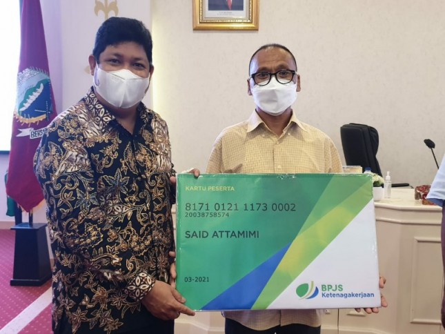 Direktur Kepesertaan BPJAMSOSTEK Zainudin menyerahkan simbolis kartu kepesertaan kepada pekerja rentan di kota Ambon