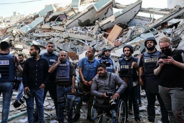 Para Jurnalis di Palestina yang berdiri di reruntuhan gedung pers yang hancur oleh Israel