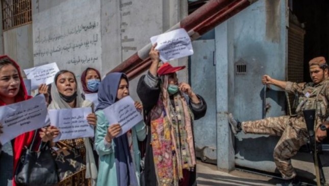 Seorang anggota Taliban menyaksikan perempuan Afghanistan selama demonstrasi menuntut hak yang lebih baik bagi perempuan di depan bekas Kementerian Urusan Perempuan di Kabul pada 19 September 2021. (Foto: AFP/Blent Kilic)/nu