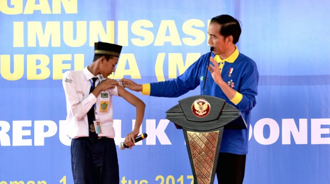 Presiden Jokowi berdialog dengan seorang siswa yang sudah memperoleh imunisasi MR, di Madrasah Tsanawiah Negeri 10 Sleman, Kelurahan Sinduharjo, Ngaglik, Kab. Sleman, Yogyakarta, Selasa (1/8) pagi. (Foto: Agung/Setkab)