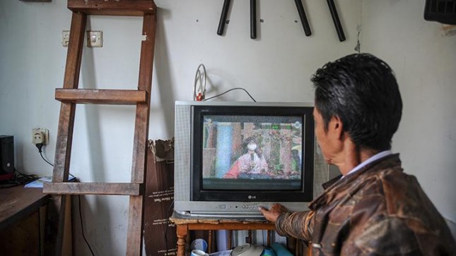 Seorang petugas keamanan menonton siaran TV analog di Cinunuk, Kabupaten Bandung, Jawa Barat, Kamis 17 Februari 2022. Kementerian Komunikasi dan Informatika akan menghentikan siaran TV analog tahap pertama pada 30 April 2022 mendatang di 12 daerah di Jawa Barat. ANTARA FOTO/Raisan Al Farisi