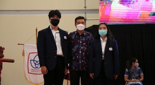 Penyematan almamater oleh Prof. Dr. Chairy, Rektor PresUniv (tengah) kepada Martin Yabes, mahasiswa Indonesia (kiri) dan Ho Bao, mahasiswa Vietnam (kanan), sebagai simbol penyambutan mahasiswa baru
