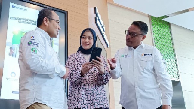 Direktur Operasi PT Bank Muamalat Indonesia Tbk Wahyu Avianto (kiri) menjelaskan pendaftaran haji melalui Muamalat Digital Islamic Network (DIN) kepada nasabah disaksikan oleh Plt Direktur Utama PT Bank Muamalat Indonesia Tbk Hery Syafril (kanan) di Jakarta