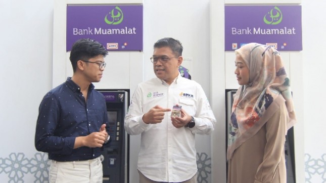 Head of Distribution & Network Management PT Bank Muamalat Indonesia Tbk Agung Prambudi (tengah) berbincang bersama karyawan yang selesai bertransaksi menggunakan kartu Shar-E Debit Muamalat di mesin ATM Muamalat Tower