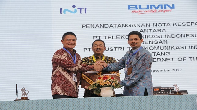 Direktur Enterprise & Business Service Telkom Dian Rachmawan dan Direktur Utama PT Inti Darman Mappangara berjabat tangan.