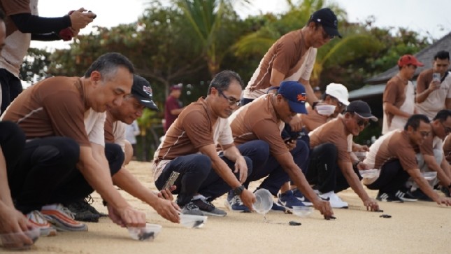 Direktur Group Business Development Telkom Indonesia, Honesti Basyir (ketiga dari kiri) dan Direktur Utama Finnet, Rakhmad Tunggal Afifuddin (ketiga dari kanan, topi hitam) saat melakukan pelepasan tukik di pantai Nusa Dua, Bali beberapa waktu lalu