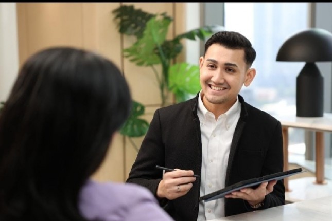 Petugas layanan BSI sedang menjelaskan produk kepada nasabah di Kantor Cabang BSI The Tower.