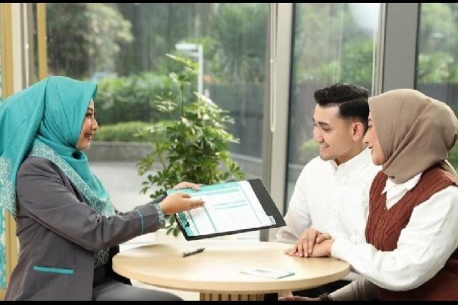 Petugas layanan BSI sedang melayani nasabah di salah satu kantor cabang.