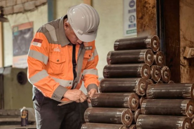 Karyawan SIG melakukan inspeksi produk carry idler di workshop CV Desra Teknik, Padang, Sumatra Barat, yang berfungsi sebagai penopang belt conveyor untuk transport material dalam proses produksi semen.