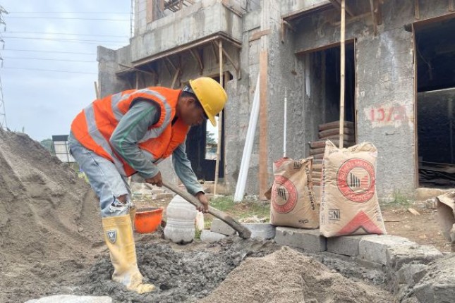 Tenaga konstruksi menyiapkan adukan material pembangunan rumah di Cluster Alexandrite, Perumahan Familia Urban, Kota Bekasi, Jawa Barat.