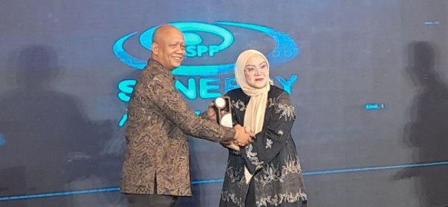 Keterangan foto : Mohamad Sigit, OJK menerima cenderamata dari ceo synergy Partner prima, Revie Fayanti
