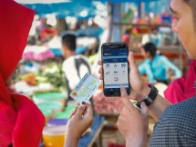 Pegawai BRI sedang tunjukan penggunaan fitur BRI ke nasabah