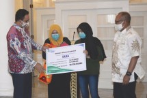 Gubernur DKI Jakarta Anies Baswedan (kiri) dan Dirut BPJAMSOSTEK Agus Susanto (kanan) saat menyerahkan santunan kepada Ahli Waris PPSU korban tabrak lari