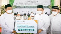 Direktur Sales & Distribution BSI, Anton Sukarna (tengah) didampingi Direktur Eksekutif Laznas BSMU, Sukoriyanto Saputro (kanan) ketika melakukan penyerahan secara simbolis bantuan pembangunan Gedung Sekolah & Perpustakaan Yayasan Investa Cendekia Amanah Depok kepada Pengasuh Pondok Pesantren Cendekia Amanah, Muhammad Cholil Nafis (kiri)