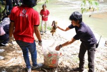 Tim SiCepat Ekspres membersihkan sampah di bantaran Sungai Ciliwung pada Kamis (12/1). 