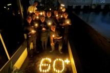 Karyawan Hotel Park Regis Arion Park menyusun lilin bentuk 60+ sebagai simbol partisipasi dalam Earth Hour 2023.