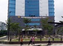 Pegawai Kementerian PUPR melewati gedung tempat mereka bekerja.
